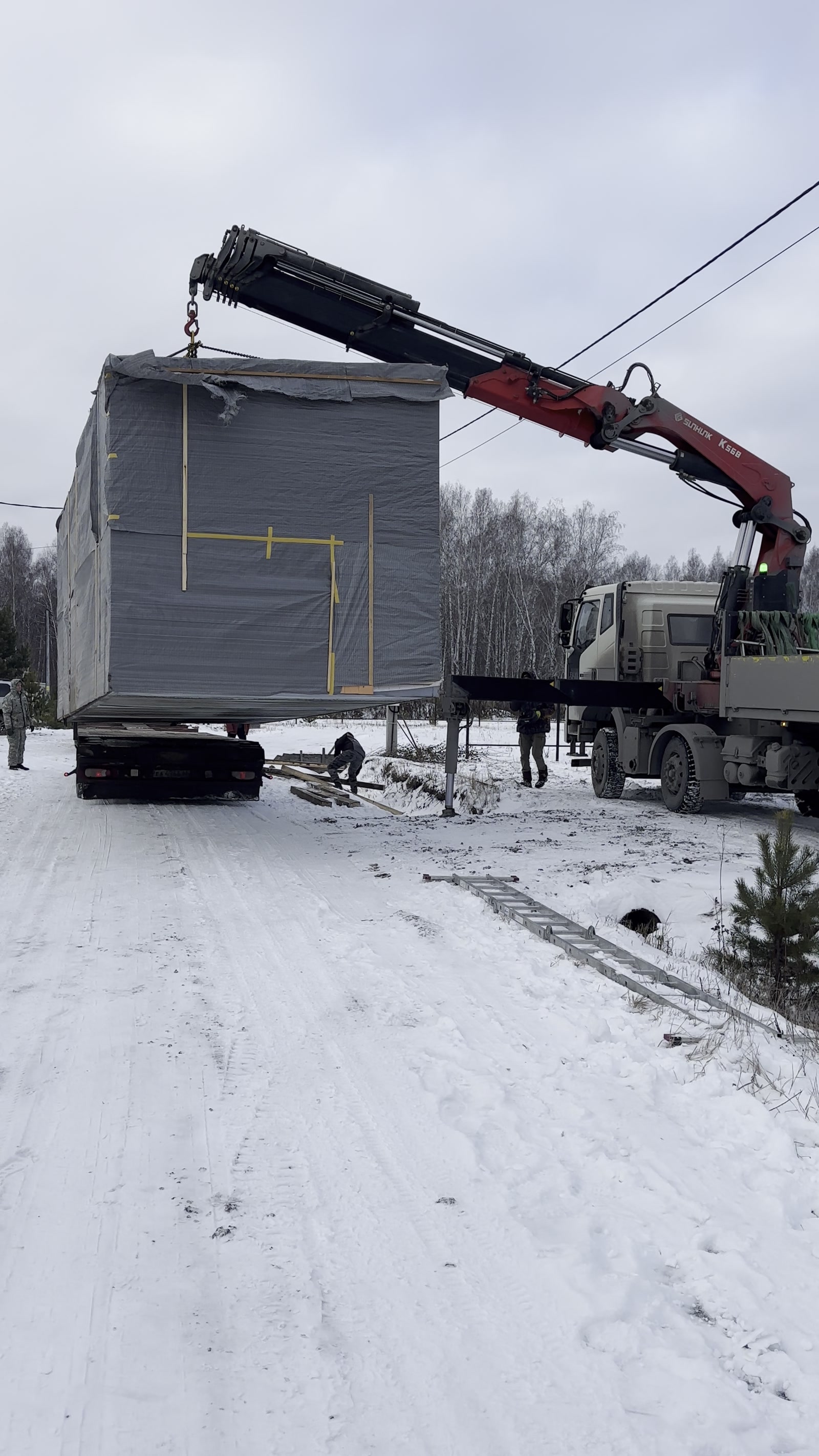 Готовый модуль ExModule поднимают краном с автомобиля зимой
